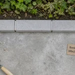 Bordure béton 100x25x5 grise le long d’une allée