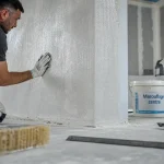 Pose toile de verre murale : marouflage centre avec brosse à encoller